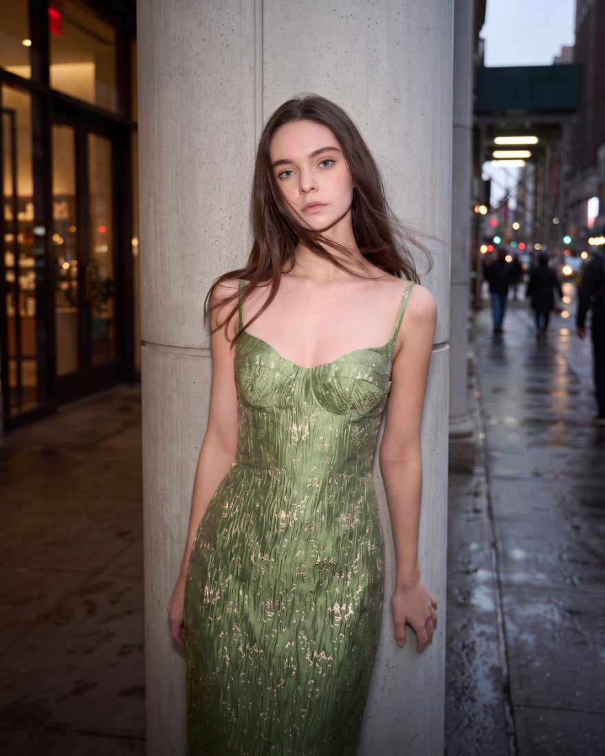 Model in a green brocade corset dress on a wet city street