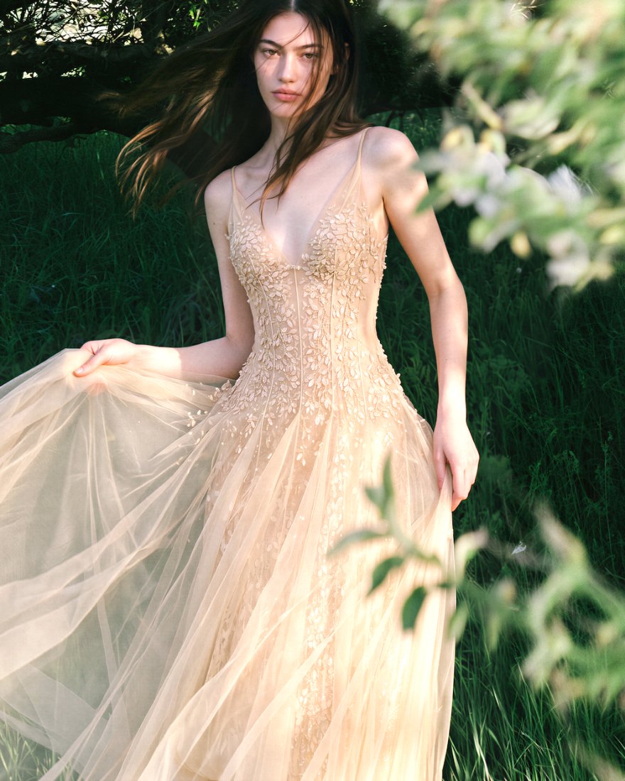 Model in a beaded tulle gown in a sunlit garden