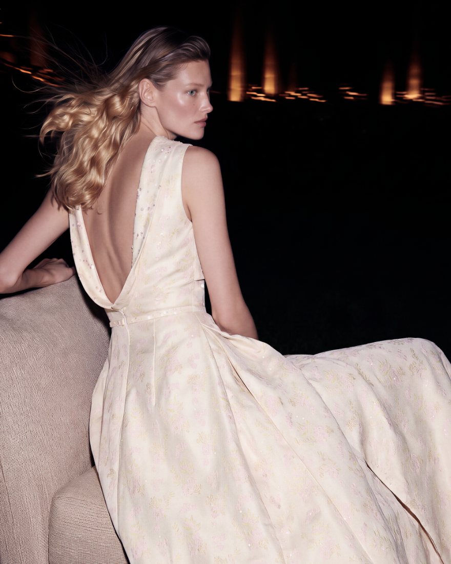 Model in an open-back gown seated at night